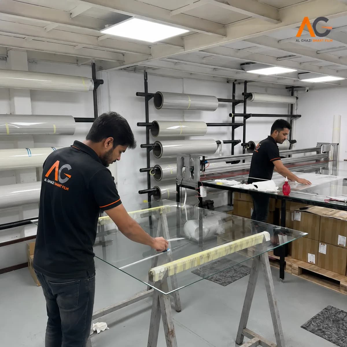 Al Ghazi technicians laminating smart film onto glass in the company workshop